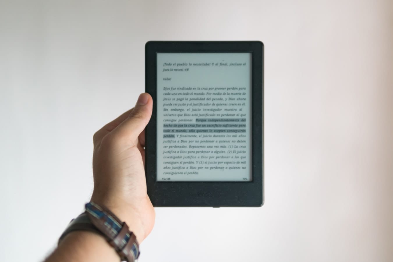 Notebook with validated ebook ideas next to a laptop showing an AI outline generator