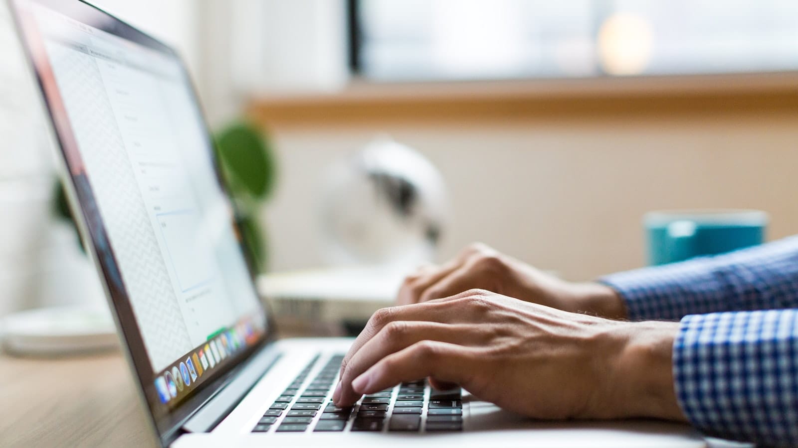 Hands typing an email on a laptop