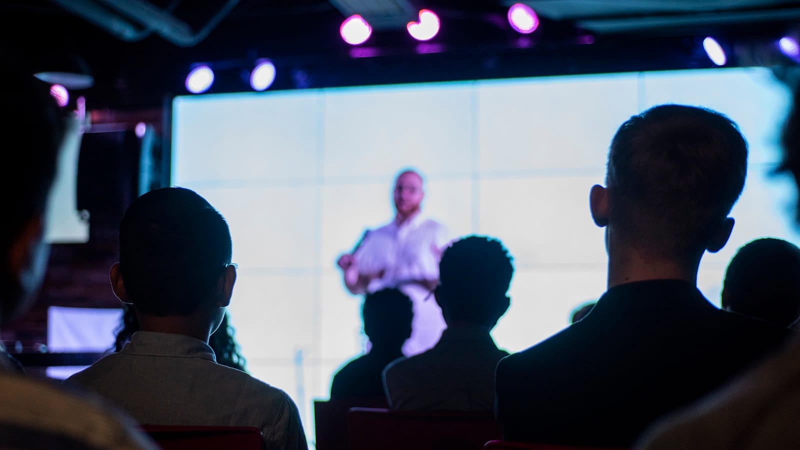 Speaker presenting to an audience with slides