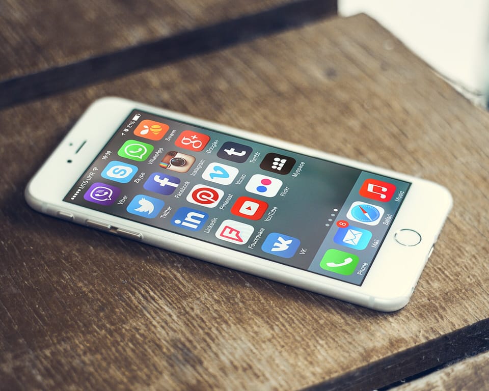 هاتف ذكي تعرض شاشته مجموعة من أيقونات تطبيقات التواصل الاجتماعي الملونة